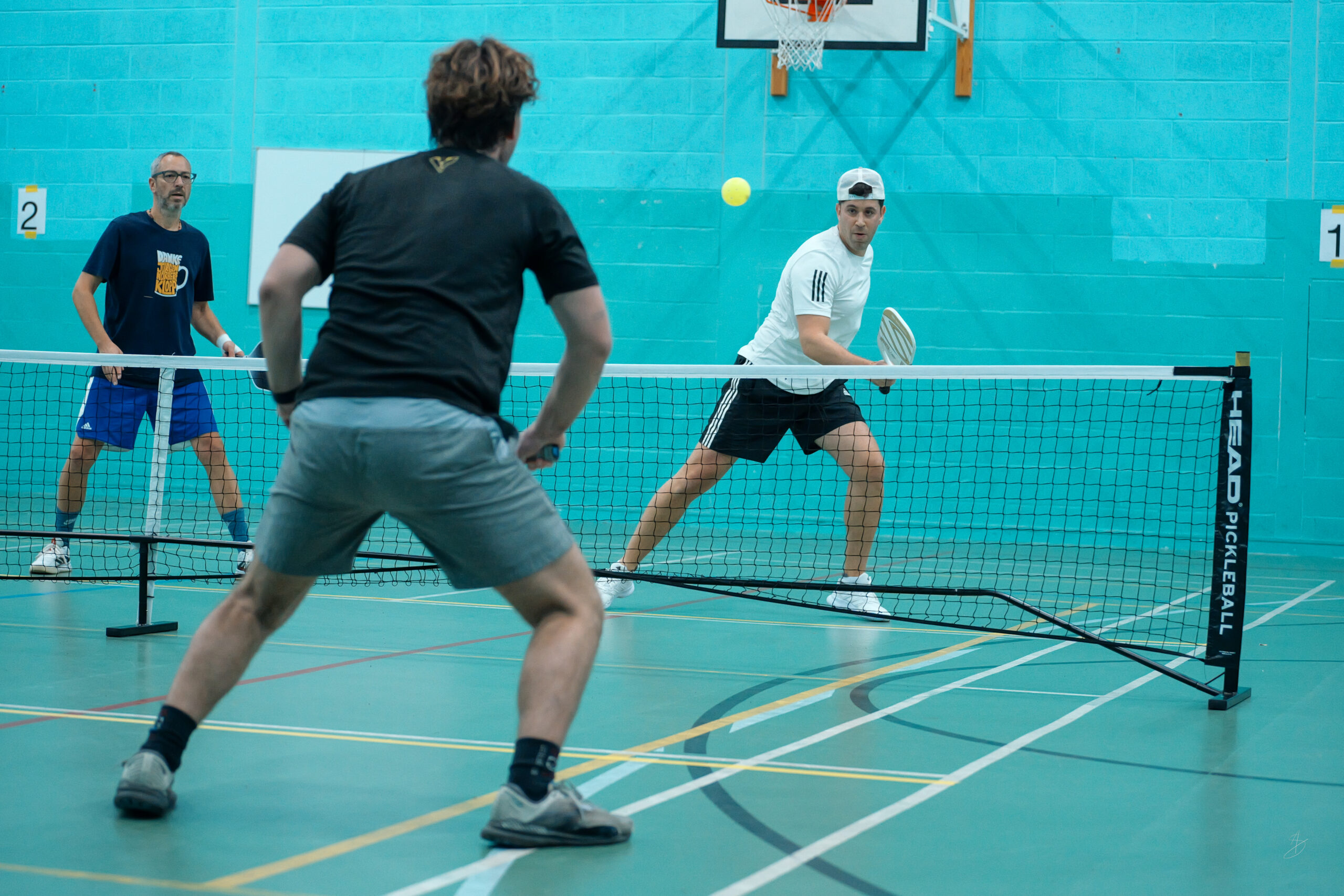 A doubles pickleball rally at the net during a Lemon Pickleball session